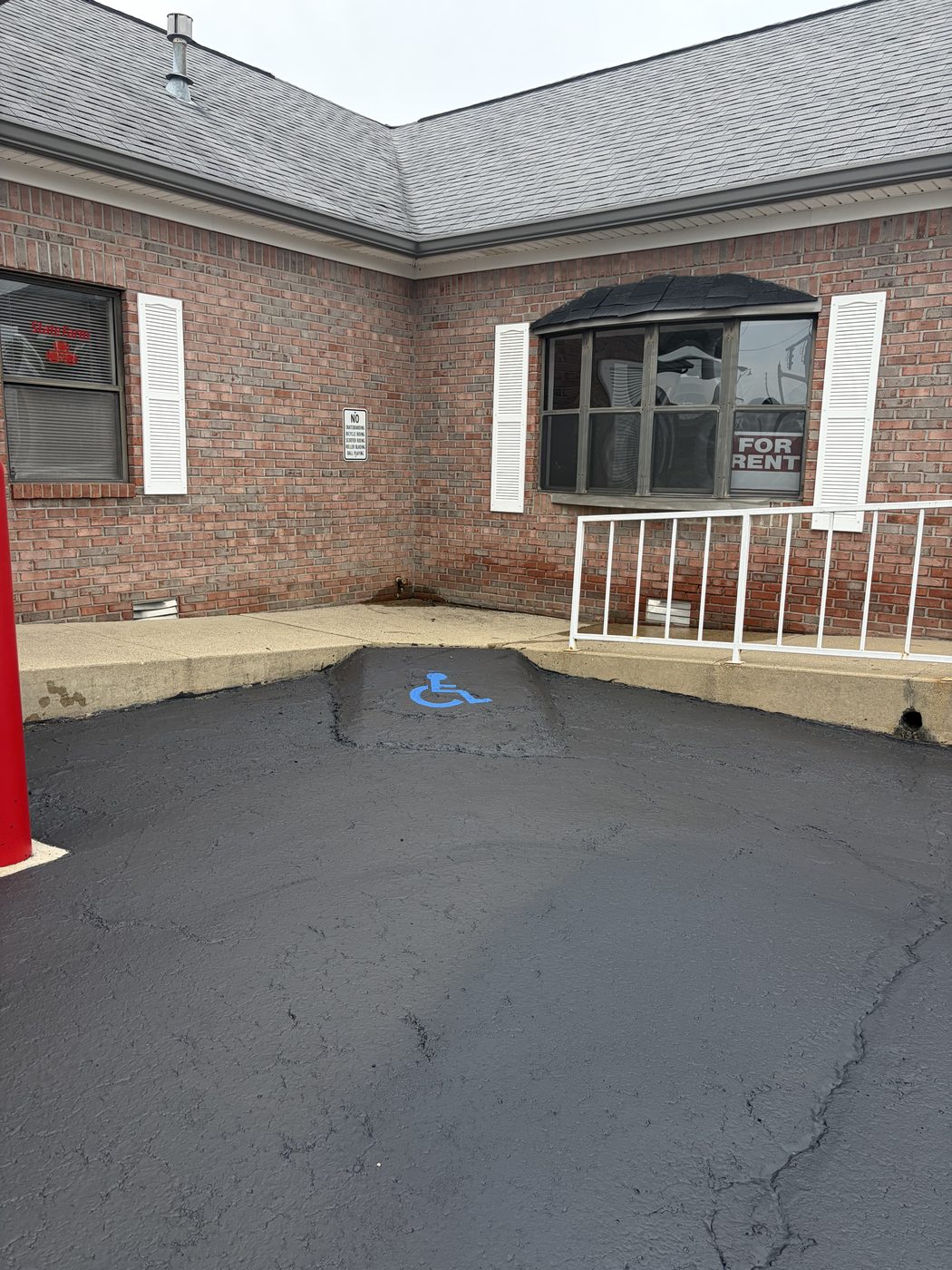 Freshly sealed commercial parking lot with a newly painted blue ADA accessible stall marking