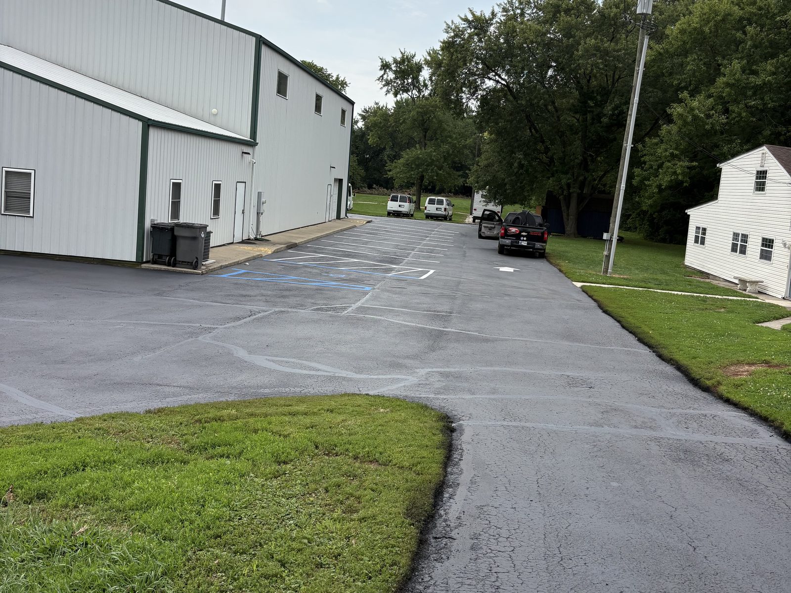Commercial parking lot after seal coating with fresh white parking stalls and blue accessible striping
